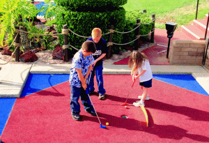 group of kids playing miniature golf