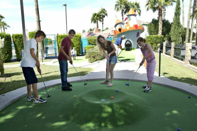 teens playing miniature golf