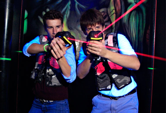 teens playing laser tag at party