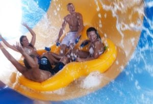 adults riding water slide tube