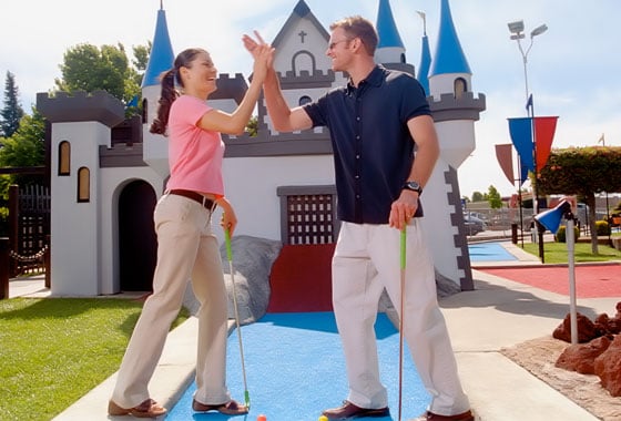 adults playing putt putt mini golf