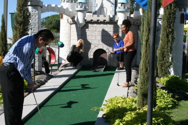 Work team playing mini golf at company party